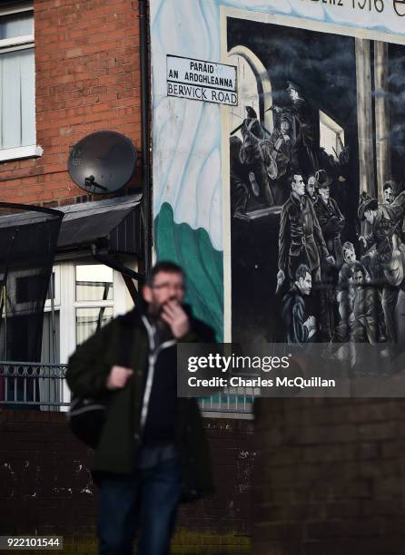 Man walks past a dual Irish-English language street sign on February 21, 2018 in Belfast, Northern Ireland. Talks to restore the Northern Ireland...