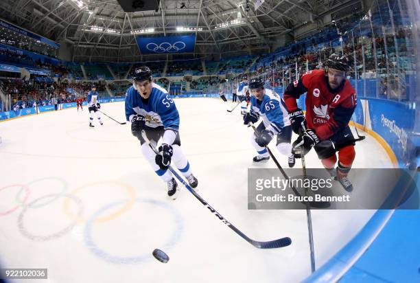 Atte Ohtamaa of Finland and Brandon Kozun of Canada compete for the puck in the third period during the Men's Play-offs Quarterfinals on day twelve...