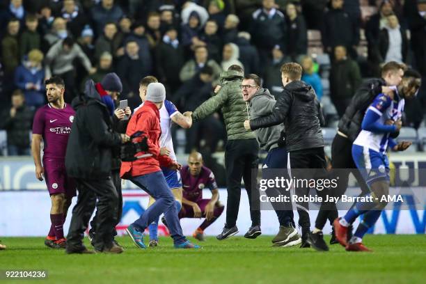 Fans of Wigna Athletic celebrate on the pitch at full time during The Emirates FA Cup Fifth Round match between Wigan Athletic and Manchester City at...