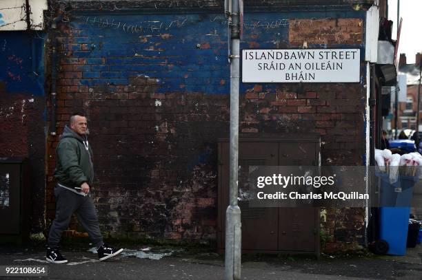Man walks past a dual Irish-English language street sign on February 21, 2018 in Belfast, Northern Ireland. Talks to restore the Northern Ireland...