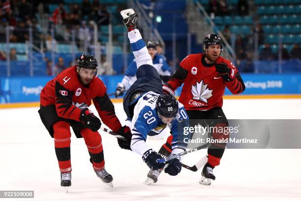 Eeli Tolvanen of Finland is upended by Chris Lee and Derek Roy of Canada in the third period during the Men's Play-offs Quarterfinals on day twelve...