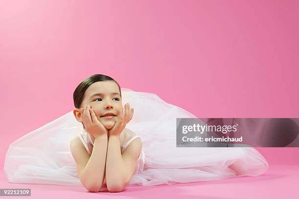 young beautiful girl lying on a pink background - greater than sign stock pictures, royalty-free photos & images