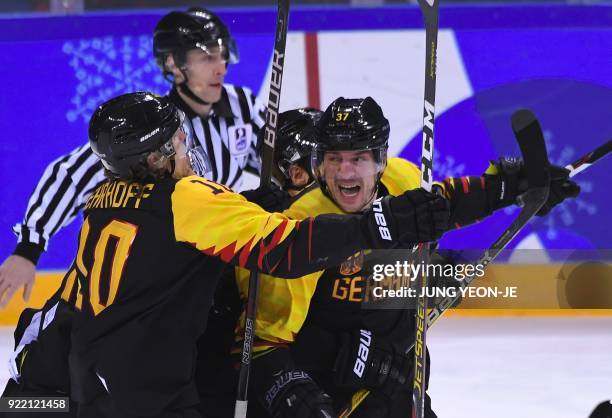 Germany's Patrick Reimer celebrates with teammates after scoring the winning goal in overtime of the men's quarter-final ice hockey match between...