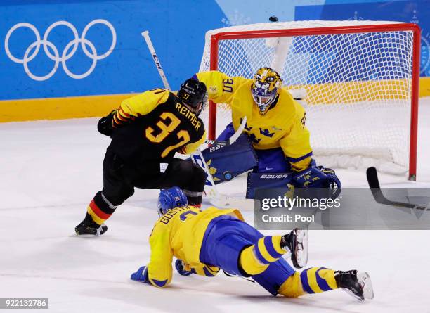 Goalie Viktor Fasth, of Sweden, stops a shot on the goal by Patrick Reimer, of Germany, left, during the overtime period of the quarterfinal round of...