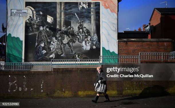 Woman walks past a dual Irish-English language street sign on February 21, 2018 in Belfast, Northern Ireland. Talks to restore the Northern Ireland...