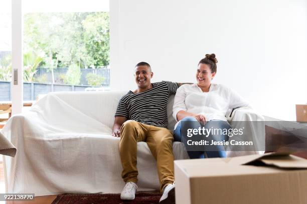 a couple relax on a sofa having moved into a new home - photohui17 stock-fotos und bilder