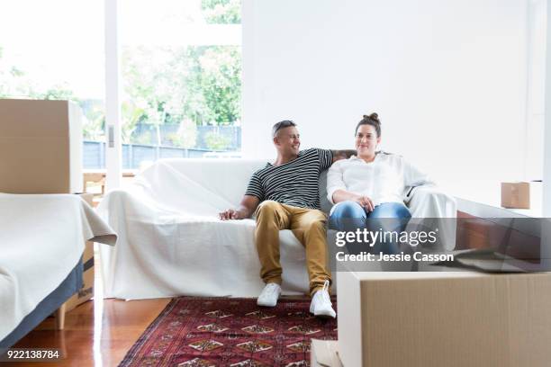 a couple relax on a sofa having moved into a new home - photohui17 stock-fotos und bilder