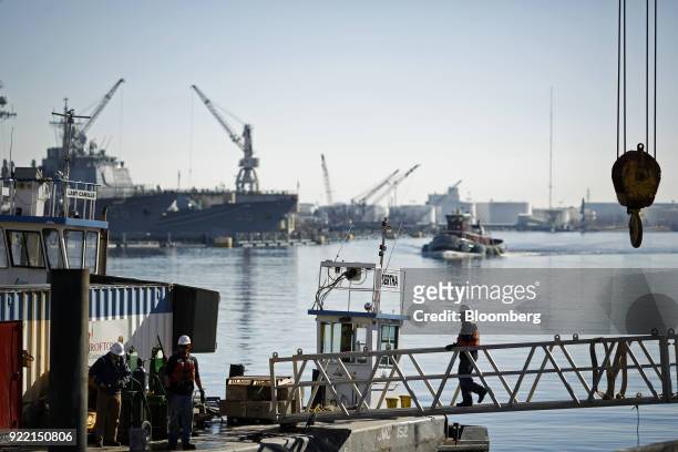 Worker walks down a gangplank adjacent to the BAE Systems Plc Norfolk Ship Repair facility on the Elizabeth River in Norfolk, Virginia, U.S., on...