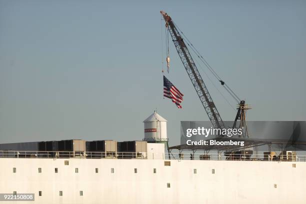 An American flag flies from a construction crane at the BAE Systems Plc Norfolk Ship Repair facility on the Elizabeth River in Norfolk, Virginia,...