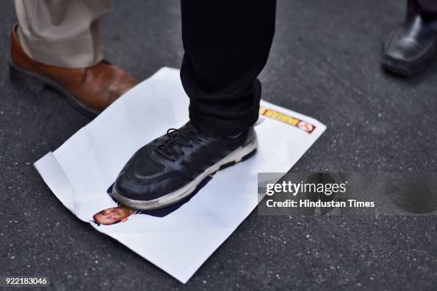 An Indian Youth Congress activist kicks the portrait of Nirav Modi during a protest at IYC office, on February 21, 2018 in New Delhi, India.