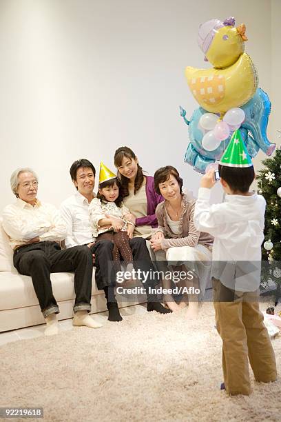 child taking snap of his family - woman hanging balloon stock pictures, royalty-free photos & images