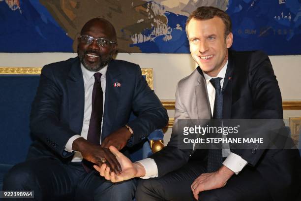 French President Emmanuel Macron meets with Liberian President George Weah at the Elysee Palace in Paris on February 21, 2018.