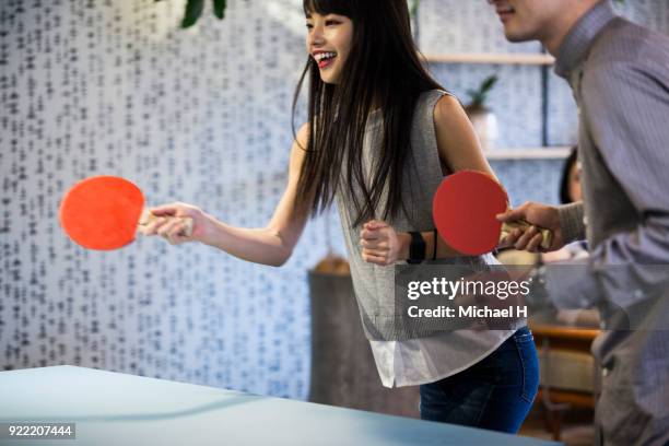 co-workers playing table tennis at the office - women's table tennis stock-fotos und bilder