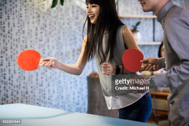 co-workers playing table tennis at the office - women's table tennis stockfoto's en -beelden