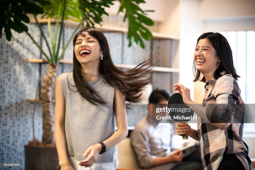 Co-workers playing table tennis at the office