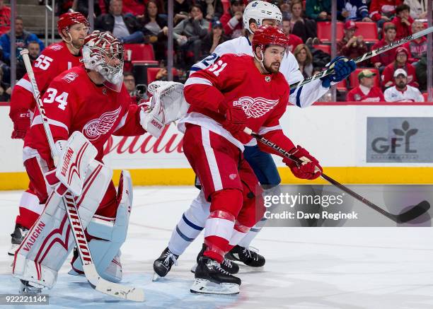 Petr Mrazek of the Detroit Red Wings follows the play as teammate Xavier Ouellet battles in front of the net with James van Riemsdyk of the Toronto...