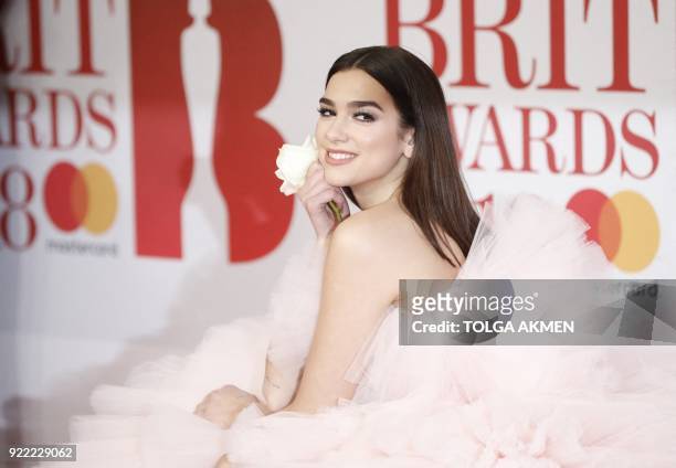 British singer-songwriter Dua Lipa poses on the red carpet on arrival for the BRIT Awards 2018 in London on February 21, 2018. / RESTRICTED TO...