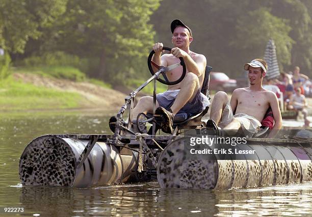 Participants in the Oconee River Raft Race peddle their raft down the river during the Seventh Annual Summer Redneck Games July 6, 2002 in East...
