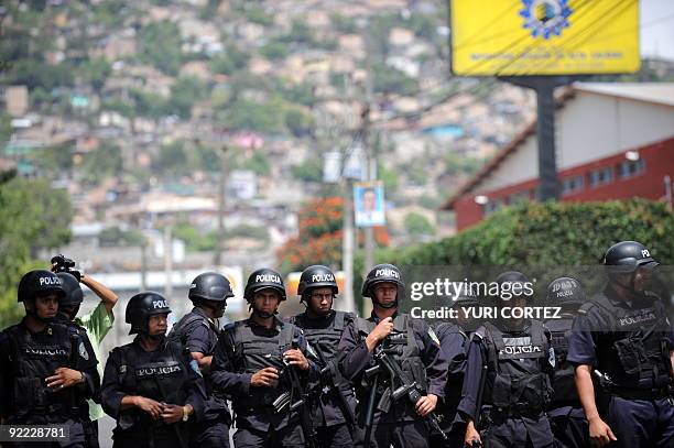 Police stand guard as supporters of Honduran deposed President Manuel Zelaya protest in a roadblock in Torocagua, Comayaguela, north from Tegucigalpa...