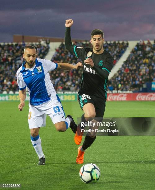 Marco Asensio of Real Madrid is tackled by Nabil El Zhar of CD Leganes during the La Liga match between Leganes and Real Madrid at Estadio Municipal...