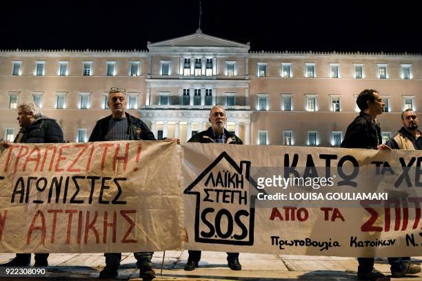 Leftist protesters hold a banner that reads 'not a house in the hands of a banker' in front of the Greek parliament in central Athens on February 21,...