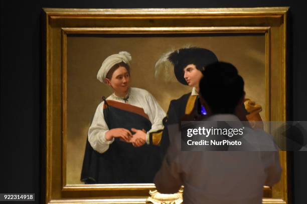 People are seen looking at the artwork La Buenaventura painted in oil on canvas by the Italian artist Caravaggio at the Exhibition 'Caravaggio an...