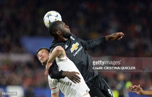 Manchester United's Belgian forward Romelu Lukaku jumps for the ball with Sevilla's French defender Clement Lenglet during the UEFA Champions League...