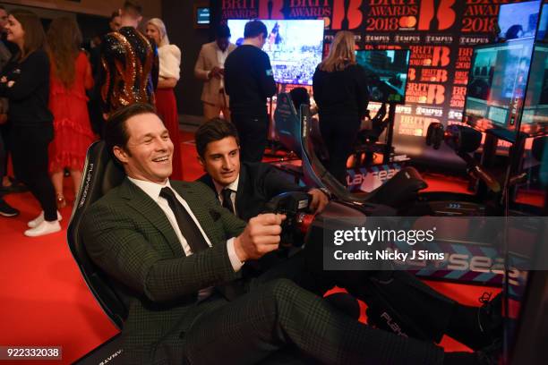 Paul Sculfur tries to beat Panasonic Jaguar Racing Formula E driver Mitch Evans' lap time on Formula E simulators during The BRIT Awards 2018...