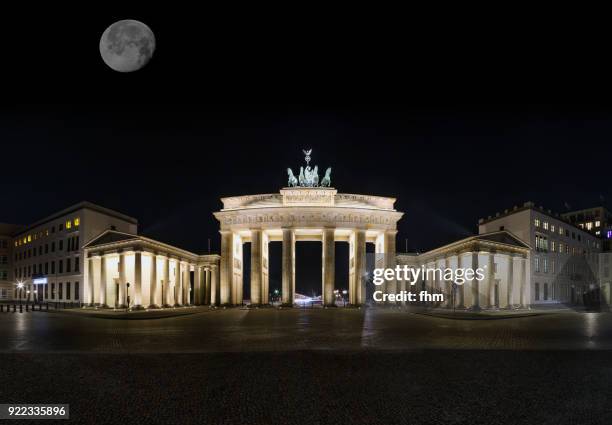 moon over the brandenburger tor (brandenburg gate) and pariser platz (berlin, germany) - quadriga statue brandenburg gate stock-fotos und bilder