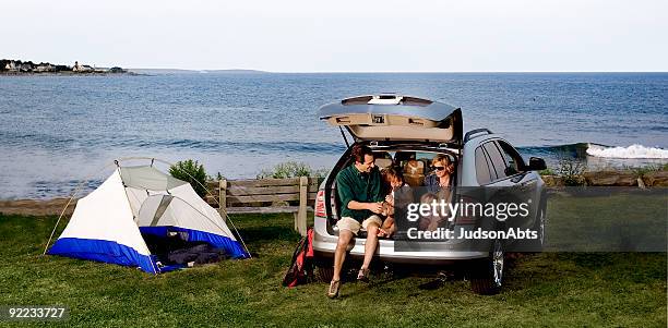 a family sitting in the back of an suv outdoors - family car stock pictures, royalty-free photos & images