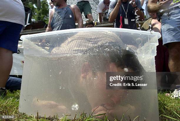 Eric Deetz participates in the Bobbing for Pigs Feet competition during the Seventh Annual Summer Redneck Games on July 6, 2002 in East Dublin,...