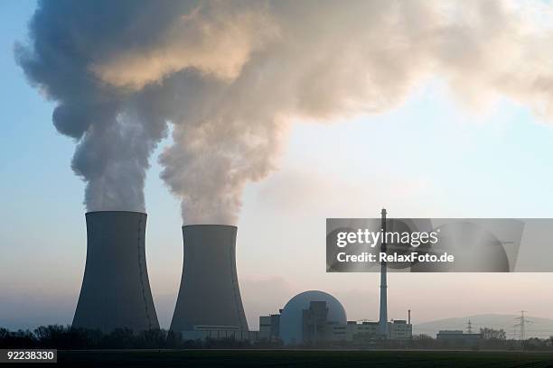 nuclear power station with steaming cooling towers at sunrise - nuclear energy stock pictures, royalty-free photos & images