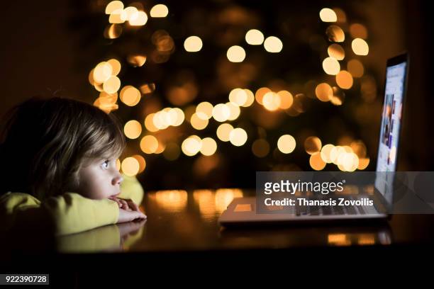 2 year old boy looking a laptop in the dark - thanasis zovoilis stock pictures, royalty-free photos & images