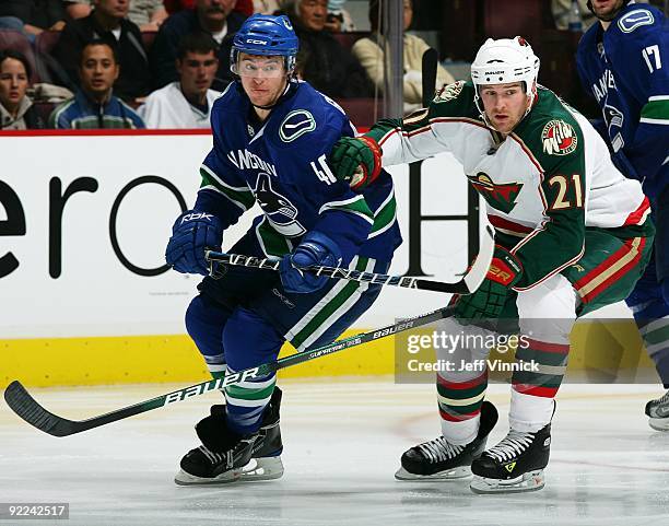 Andy Hilbert of the Minnesota Wild and Michael Grabner of the Vancouver Canucks skate up ice during their game at General Motors Place on October 17,...