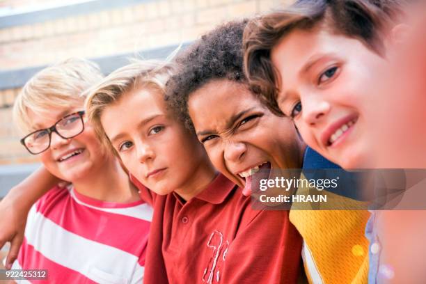 boy teasing while standing with friends in school - teasing stock pictures, royalty-free photos & images