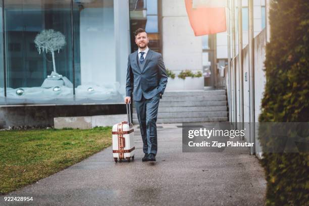 zakenman met zijn koffer verlaten van zijn kantoor - bringing home the bacon engelse uitdrukking stockfoto's en -beelden