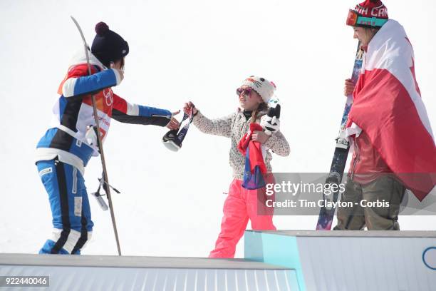 Marie Martinod of France after winning the silver medal is handed her ski goggles for the podium presentation by her daughter Melirose during the...