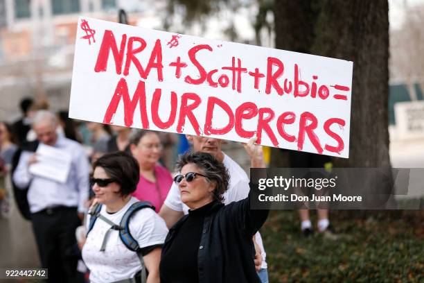 An activist holds up a placard during a rally at the Florida State Capitol building to address gun control on February 21, 2018 in Tallahassee,...
