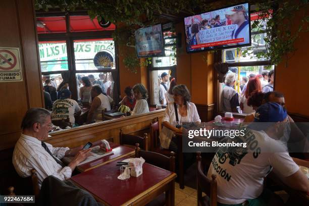 Demonstrators are seen from inside a restaurant's window during a protest against President Mauricio Marci's economic policies in Buenos Aires,...