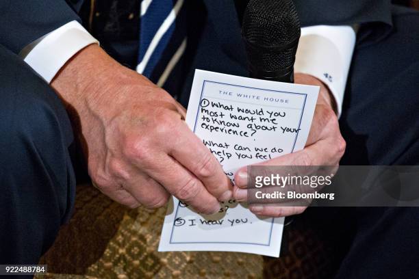 President Donald Trump holds a note during a listening session on gun violence with high school students, teachers and parents in the State Dining...