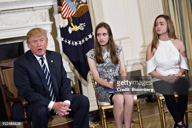 President Donald Trump, left, speaks as Carson Abt, center, and Ariana Klein, students from Marjory Stoneman Douglas High School, participate in a...