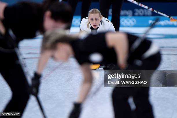 Russia's Victoria Moiseeva watches as her teammates brush in front of the stone during the curling women's round robin session between the Olympic...