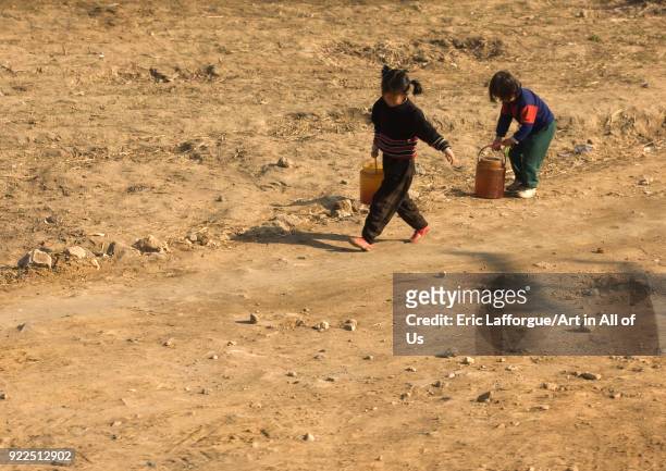 North Korean children bringing back buckets full of water from a well in the countryside, South Pyongan Province, Nampo, North Korea on April 13,...