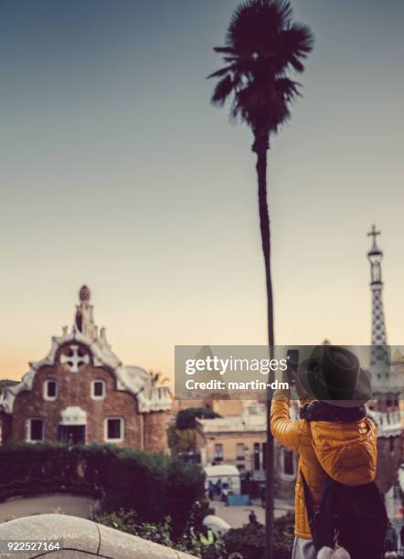 tourist taking photos at park guell,barcelona - winter barcelona stock pictures, royalty-free photos & images