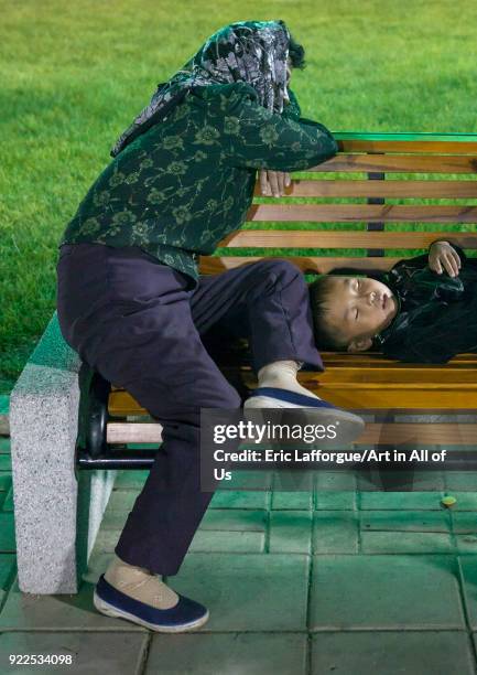 North Korean mother and her son sleeping on a bench in a park at night, Pyongan Province, Pyongyang, North Korea on September 14, 2012 in Pyongyang,...