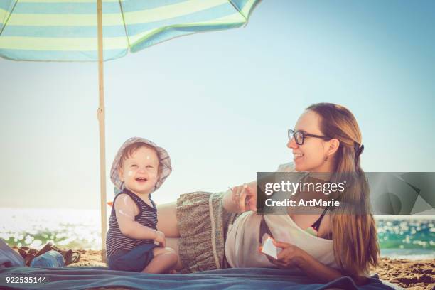 sun protection - baby suncream stock pictures, royalty-free photos & images