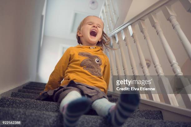 laughing girl (4-5) having fun sliding down carpeted stairs - children misbehaving stock pictures, royalty-free photos & images