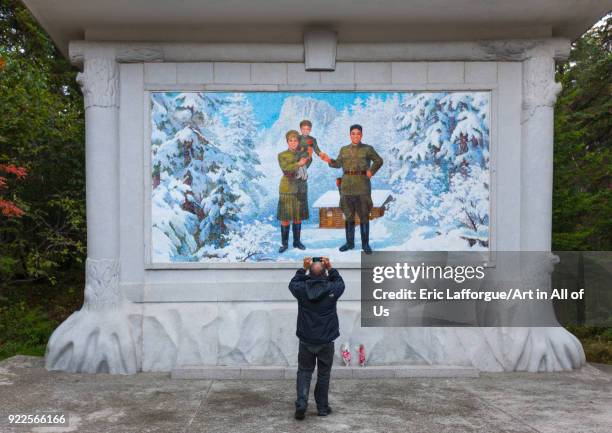 Foreign tourist taking a picture of a propaganda fresco depicting Kim il song as a child with his parents, Ryanggang Province, Samjiyon, North Korea...
