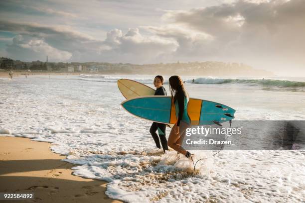 esperti surfisti hanno terminato la sessione mattutina di surf a sydney - waves crashing foto e immagini stock