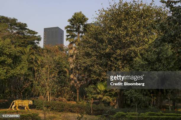 Tiger sculpture stands in a park as the Trump Towers Pune complex, developed by Panchshil Corp Park Pvt., stands in the distance in Pune,...